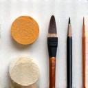 Assortment of blending tools including tortillons, paper stumps, chamois, and blending brushes on a neutral background.